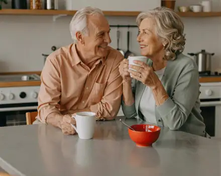 Elderly Couple Enjoying Coffee at Kitchen Table man and woman old