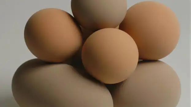 Stacked Fresh Eggs on White Background light brown