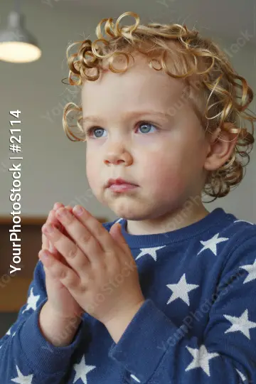 Young child praying close-up blurred background kid