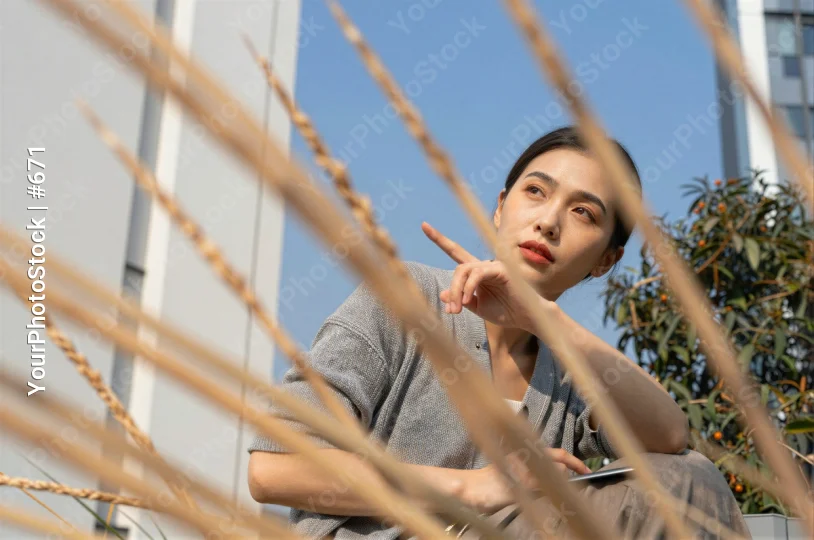 Young Woman Sitting Thoughtfully on Bench grey t-shirt