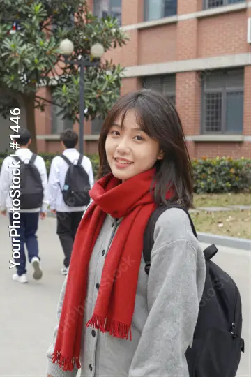 Young Asian Woman Smiling on Sidewalk brick building