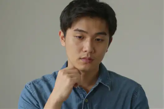 Young Asian Man Deep in Thought serious expression