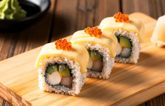 Sushi Rolls with Sesame Seeds on a Cutting Board