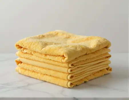 Neatly Folded Yellow Towels on White Marble tidy hotel