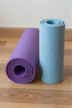 Yoga Mats Rolled Up on Wood Floor wooden floor