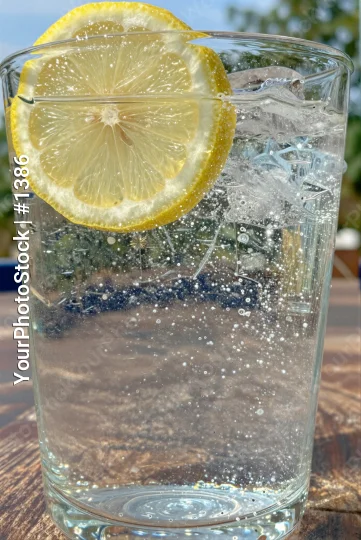 Glass of Water with Lemon Slice ice cubes outdoor