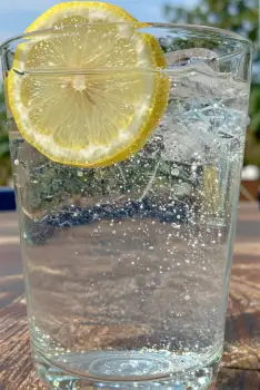 Glass of Water with Lemon Slice ice cubes outdoor