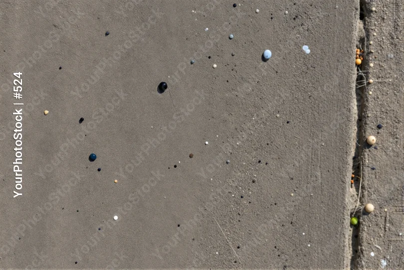 Close-up of Rough Concrete Surface with Holes and Grass