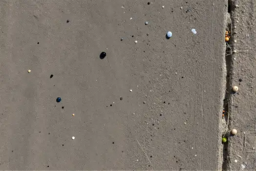 Close-up of Rough Concrete Surface with Holes and Grass