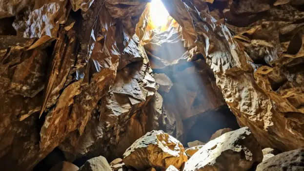 Bright Light Through Cave Ceiling, Stalactites and Boulders