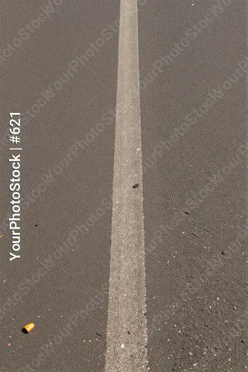 Uneven white line on asphalt with cigarette near parking lot
