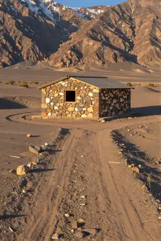 Desert Cabin in Snow-Capped Mountains landscape