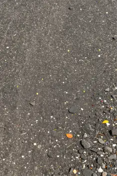 Wet Asphalt Surface with Pebbles and Objects rocks texture