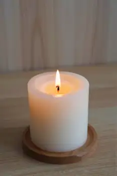 Lit White Candle on Wooden Surface lit candle