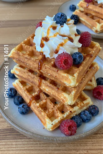 Stack of Golden Brown Waffles with Whipped Cream and Caramel Sauce