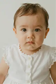 Serious Baby Girl in White Dress serious expression