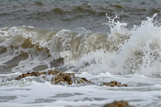 Dramatic Wave Crashing onto Rocky Shore turbulent