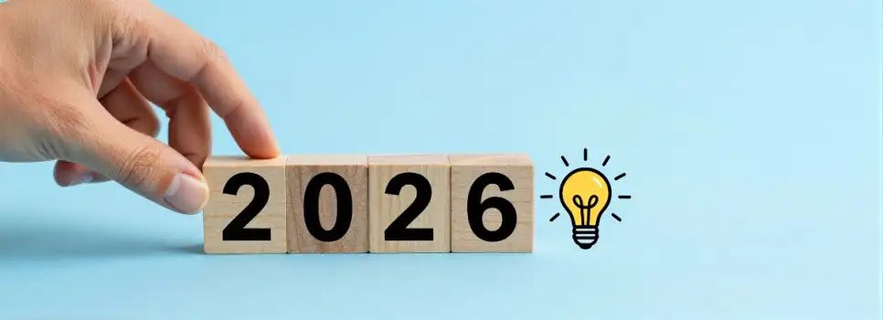 Hand Placing Wooden Block with Number 2026 on Light Blue Background