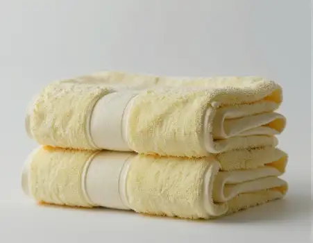 Soft Yellow Towels Folded Neatly on White Background hotel