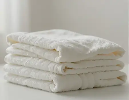 Neatly Folded White Towels on Surface textured hotel