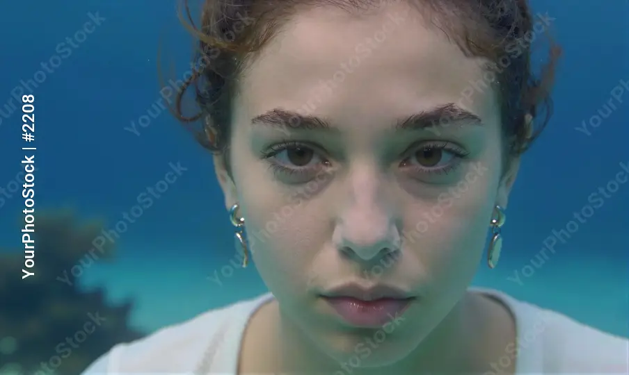 Young woman underwater portrait, serious expression