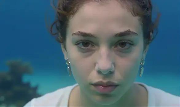 Young woman underwater portrait, serious expression