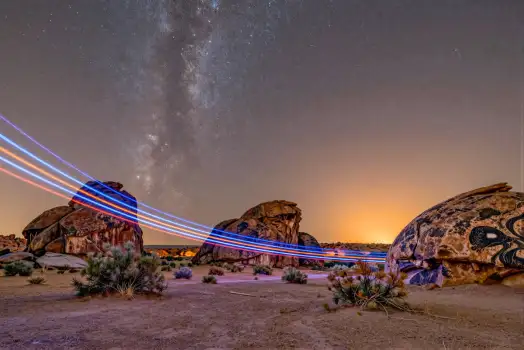 Desert Landscape at Sunset with Milky Way and Light Trails