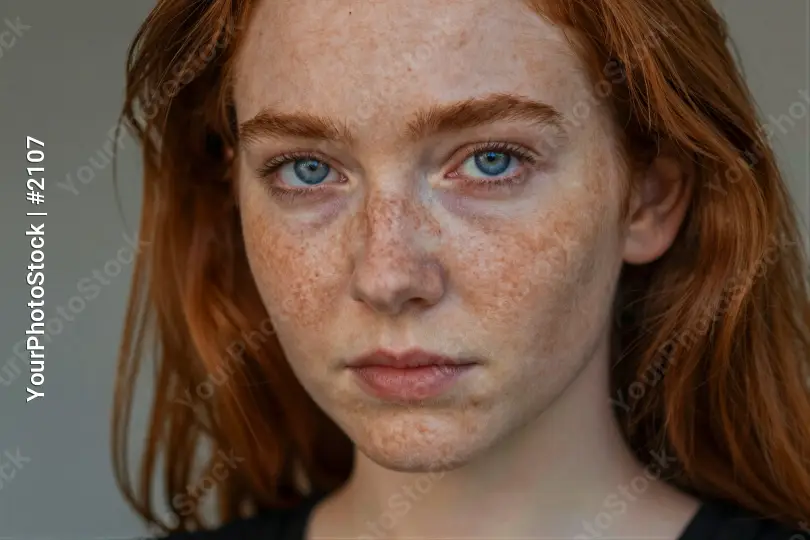 Young Woman with Red Hair and Freckles Looking Serious model