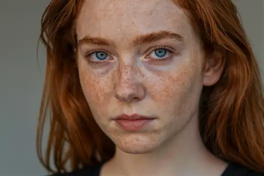 Young Woman with Red Hair and Freckles Looking Serious model