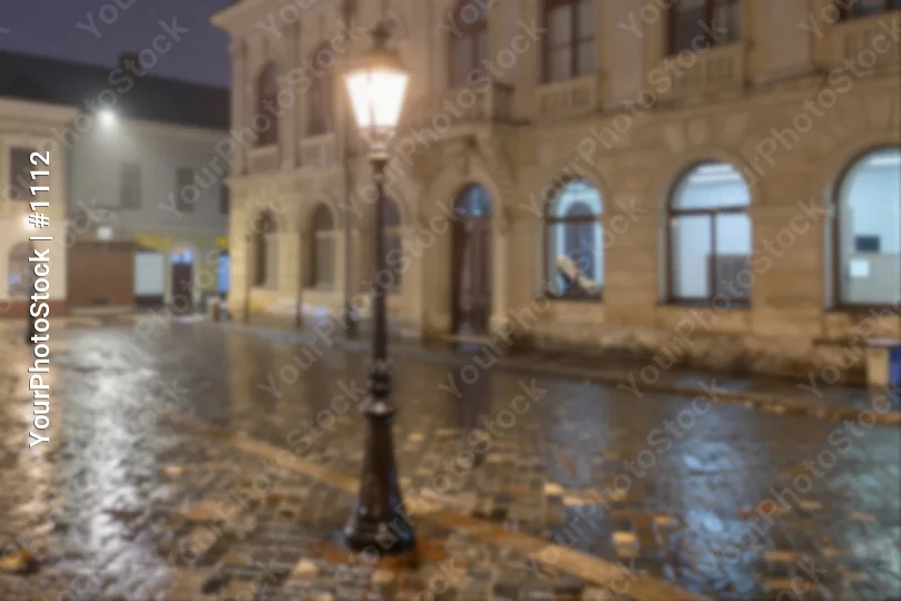 Wet Night Street with Fallen Leaves and Dilapidated Building blurred