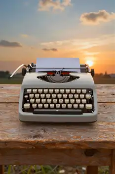 Old Typewriter on Wooden Table at Sunset vintage