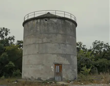 Abandoned Concrete Silo with Cracks in Overcast Sky