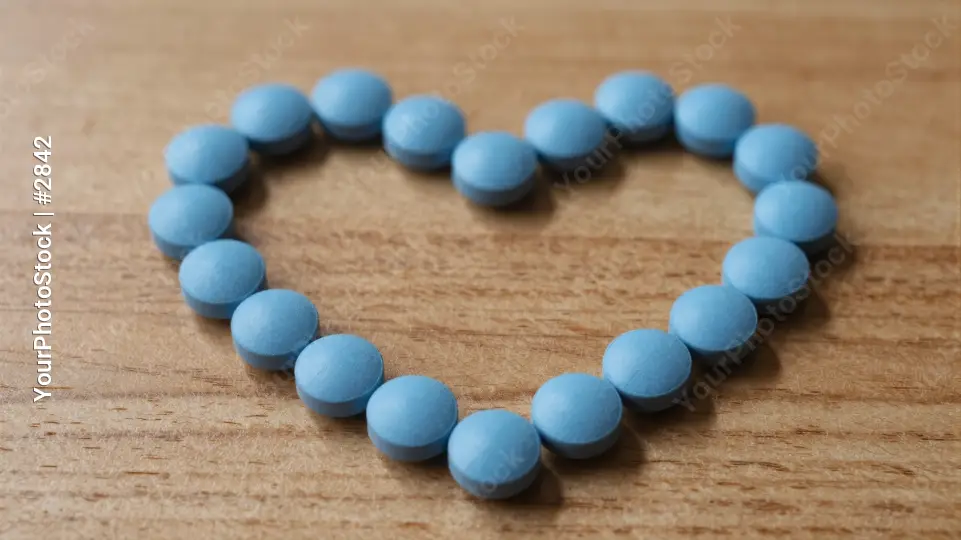 Heart-shaped pills on a wooden surface