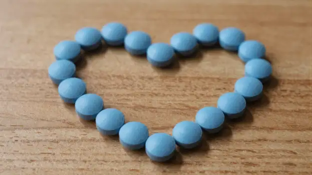 Heart-shaped pills on a wooden surface