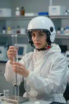 Young Woman in Lab Coat Holding Test Tube helmet