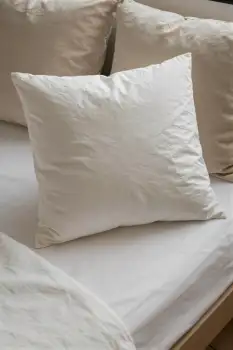 Close-up of neatly arranged square pillows on a bed hotel
