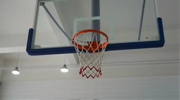 Metal Basketball Hoop Hanging from Ceiling in Gymnasium