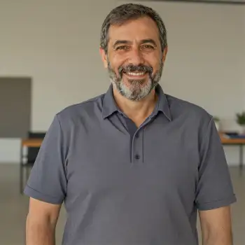 Middle-aged man with beard smiling at camera in office