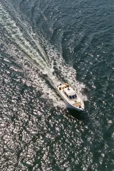 White Boat Sailing Through Turbulent Ocean waves