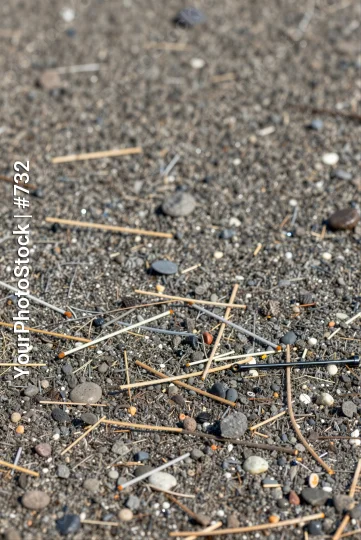Close-up of chaotic asphalt ground with rocks and twisted sticks