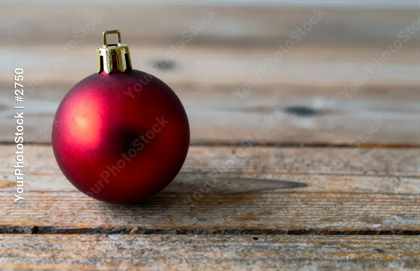 Vibrant Red Christmas Ornament on Rustic Wooden Background