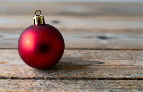 Vibrant Red Christmas Ornament on Rustic Wooden Background