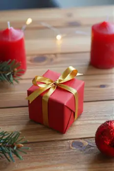 Red Gift Box with Gold Ribbon on Wooden Table