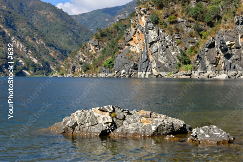 Calm Lake with Rocky Shoreline and Mountains calm water