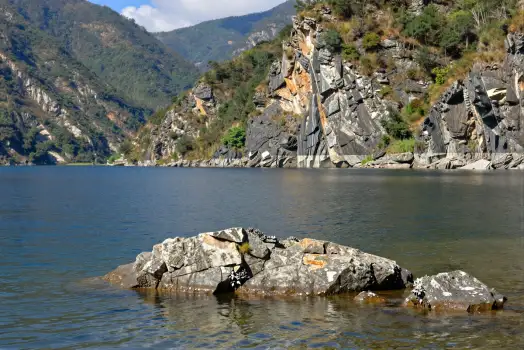 Calm Lake with Rocky Shoreline and Mountains calm water