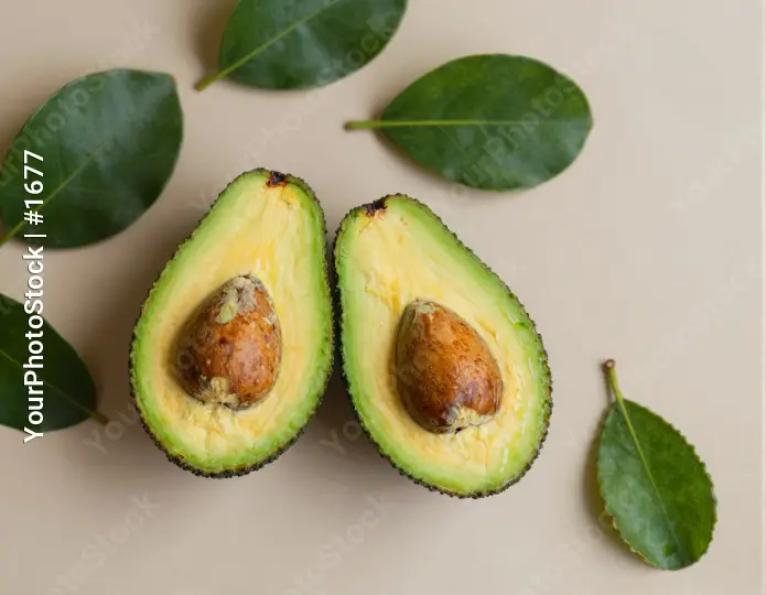 Avocado halves on beige background green flesh