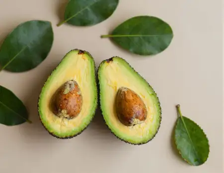 Avocado halves on beige background green flesh