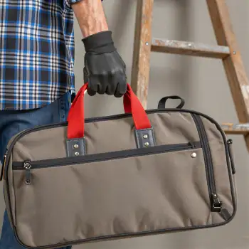 Person Holding Duffel Bag with Handles beige red