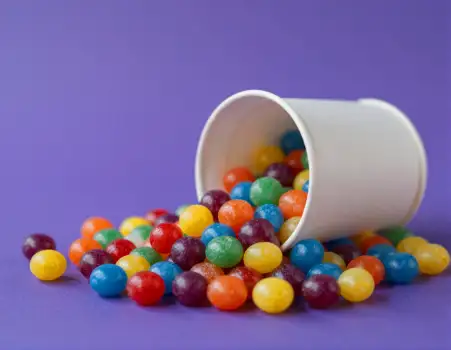 Colorful Jelly Beans Spilling Out of White Cup