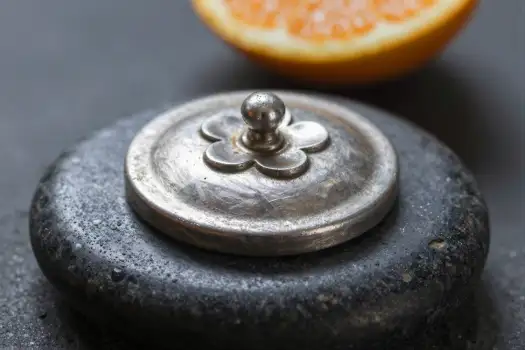 Silver Flower Lid on Metal Container with Orange Slice